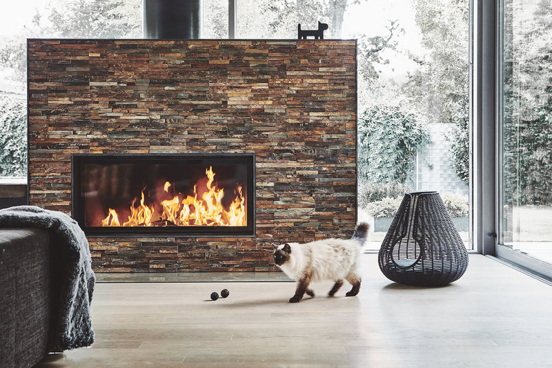 A cat beside a woven MiaCara Perla cat cave in a modern home